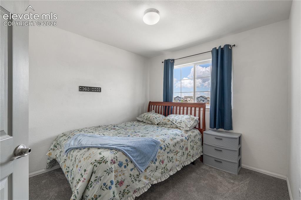 Image 31 of 41: Carpeted room with white walls, a six-panel interior door, and bi-fold clos
