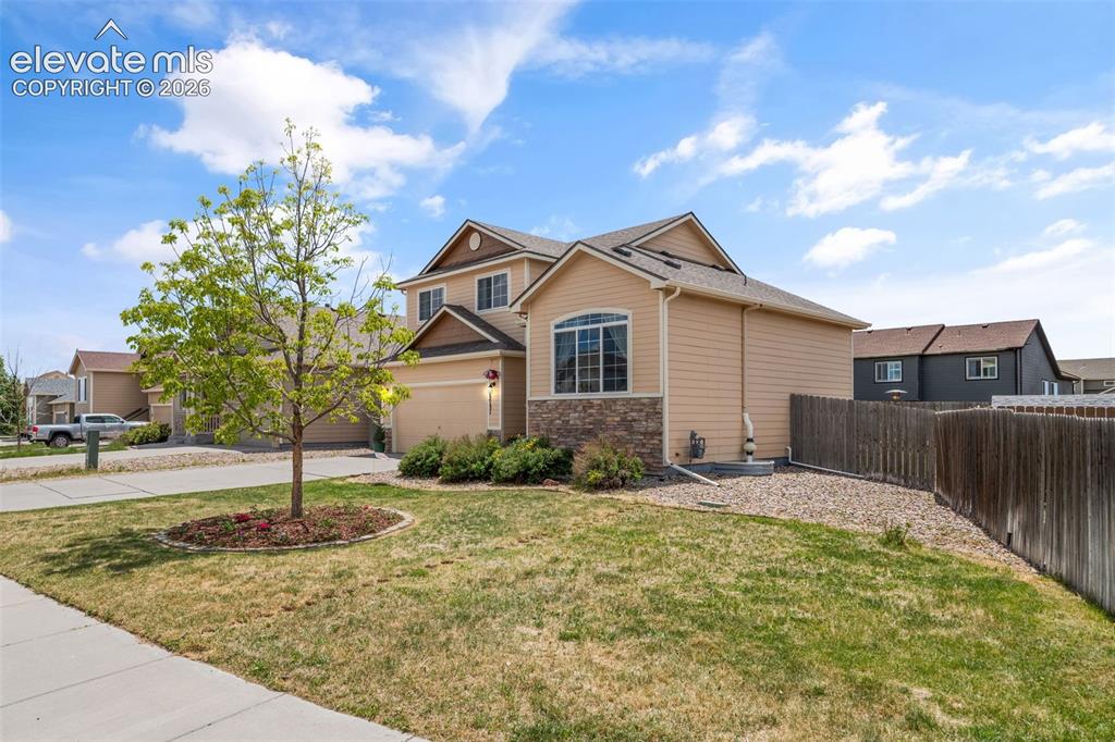 Image 4 of 41: Two-story residence featuring light-toned siding, a stone facade accent, an