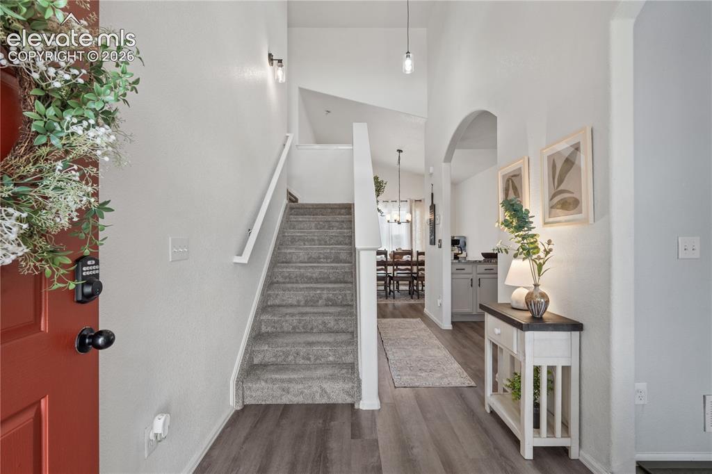 Image 6 of 41: Entryway featuring stone facade accents, concrete steps, a storm door, and