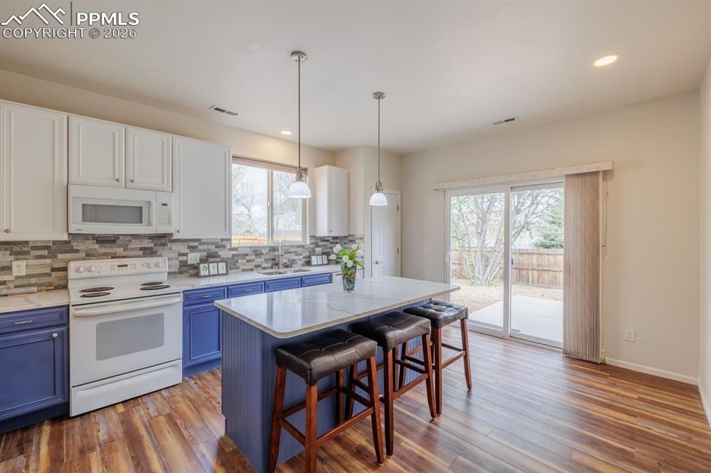Image 12 of 36: Flowing floor plan with the sliding door out to the concrete patio and yard