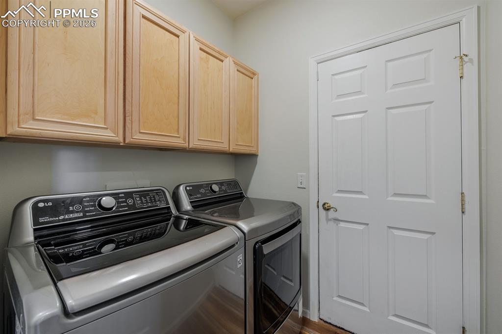 Image 24 of 36: Nice laundry room with cabinets and door to garage
