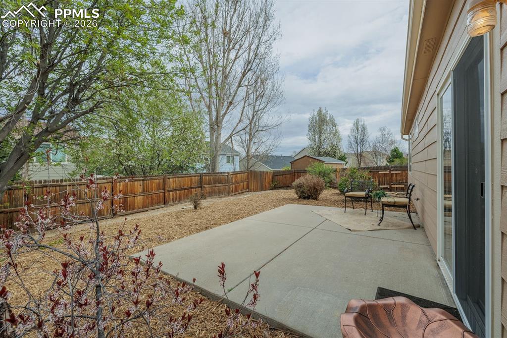 Image 25 of 36: Lovely yard with mature trees and easy care with drip system