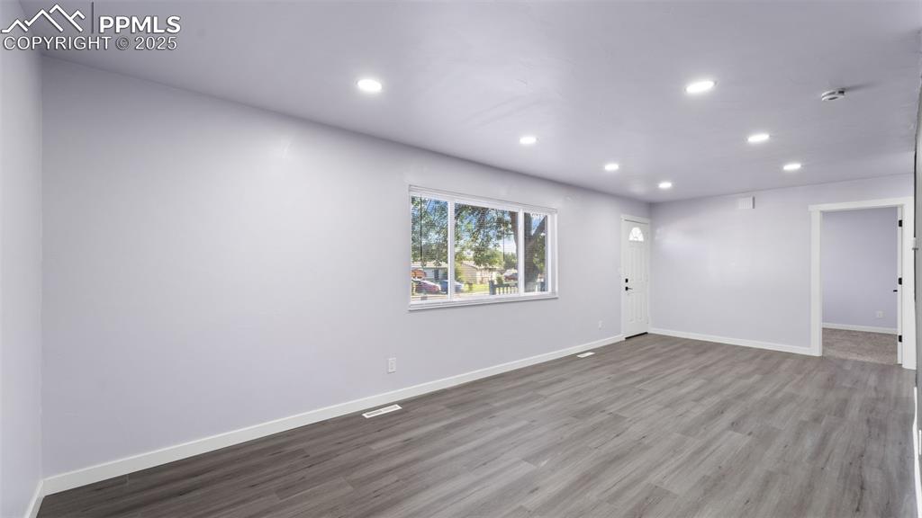 Image 11 of 28: Empty room with wood finished floors and recessed lighting
