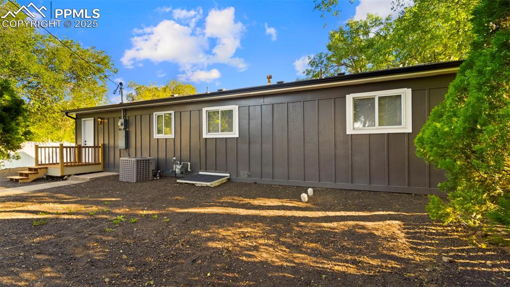 Image 20 of 28: Rear view of property with board and batten siding and a deck