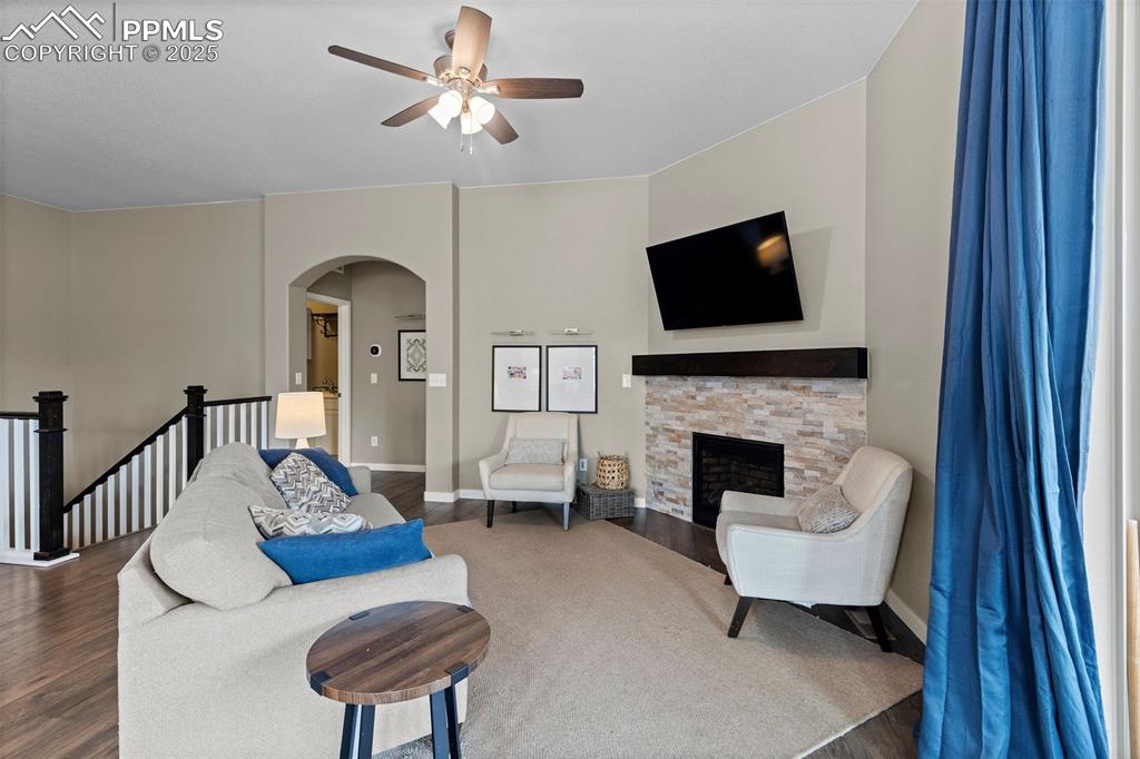 Image 15 of 40: Living area featuring arched walkways, dark wood-type flooring, a ceiling f
