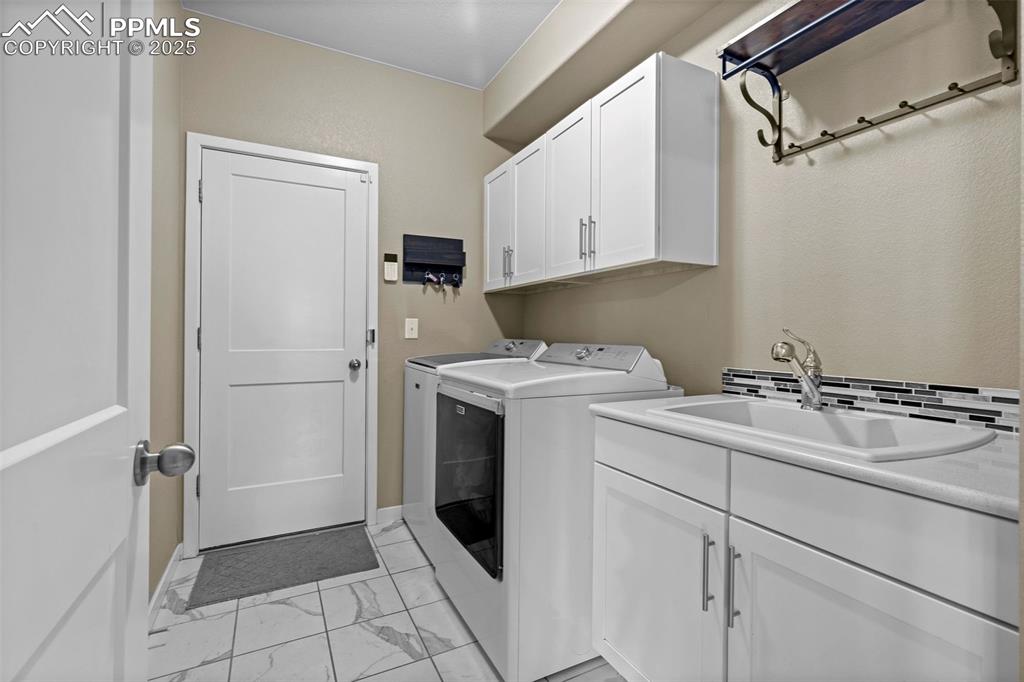 Image 18 of 40: Laundry room with utility sink and extra storage