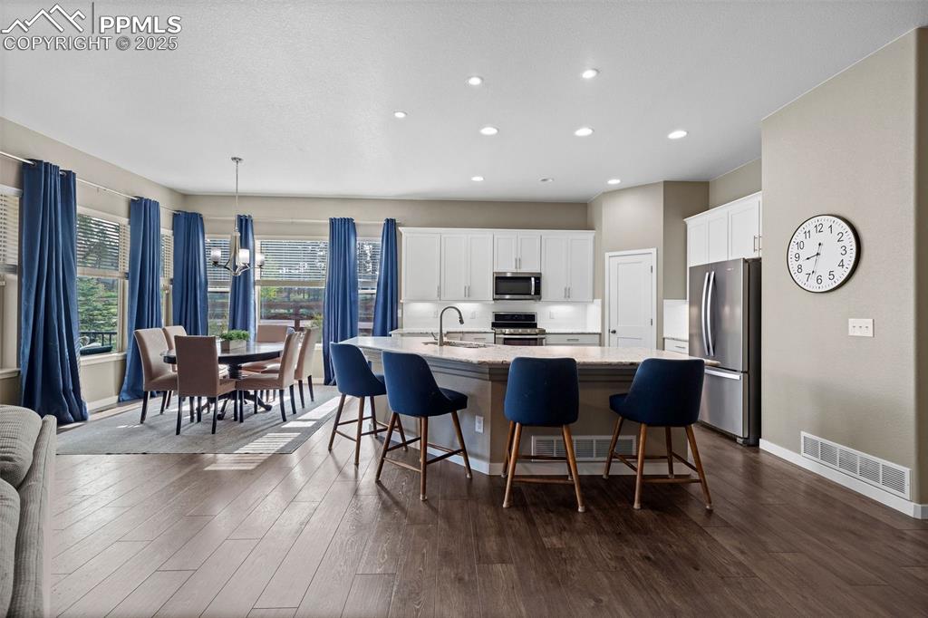 Image 7 of 40: Kitchen with appliances with stainless steel finishes, a large island, rece