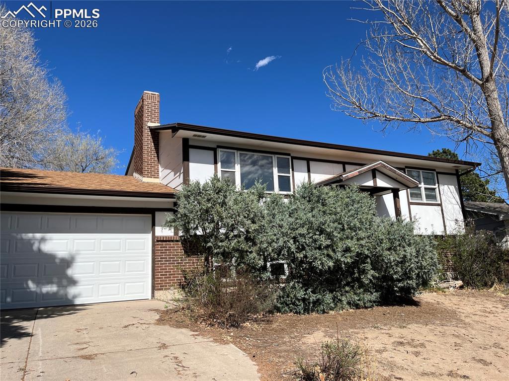 Image 13 of 13: View of front of house featuring an attached garage, concrete driveway, a c