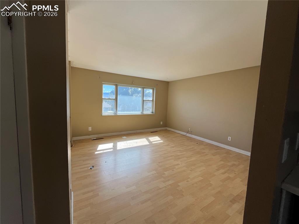 Image 4 of 13: Unfurnished room with baseboards and light wood finished floors