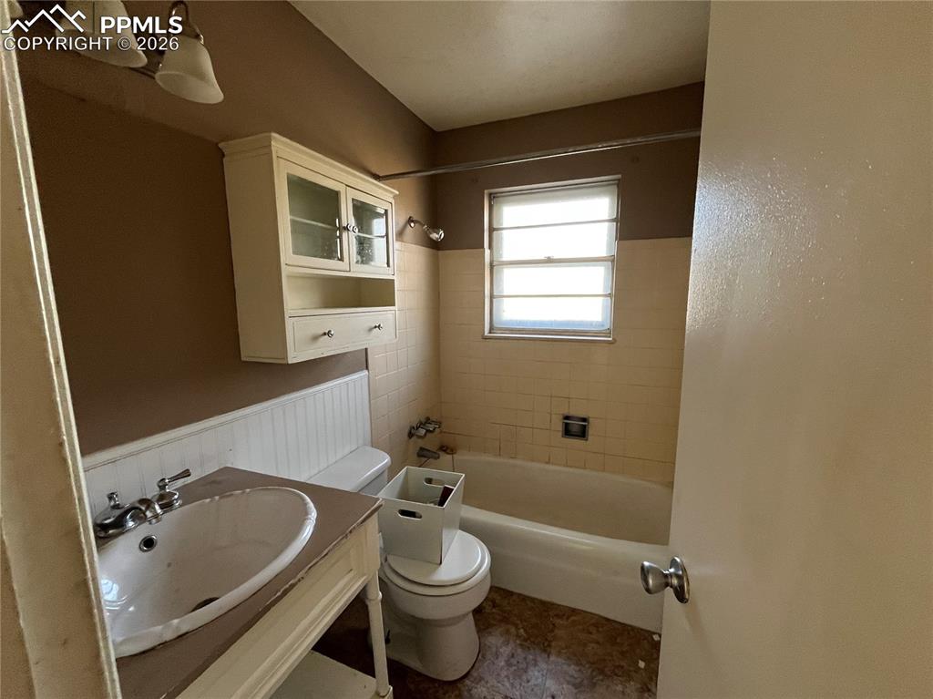 Image 5 of 13: Full bath with shower / bath combination, vanity, and wainscoting