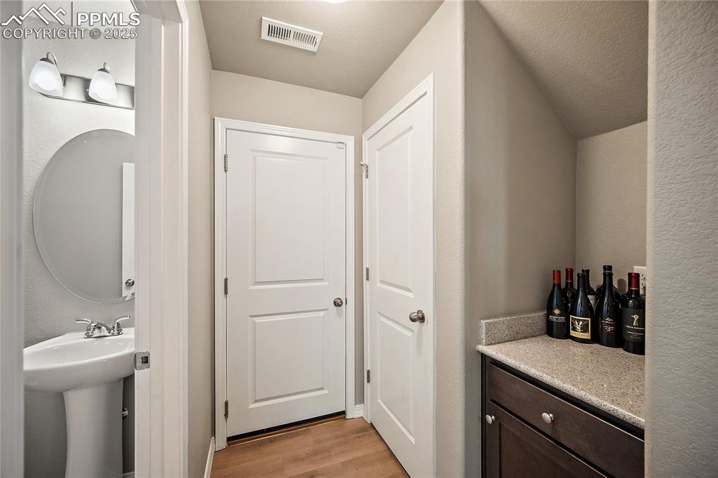 Image 15 of 36: 1/2 bath, coffee or wine bar space closet and door to the garage.