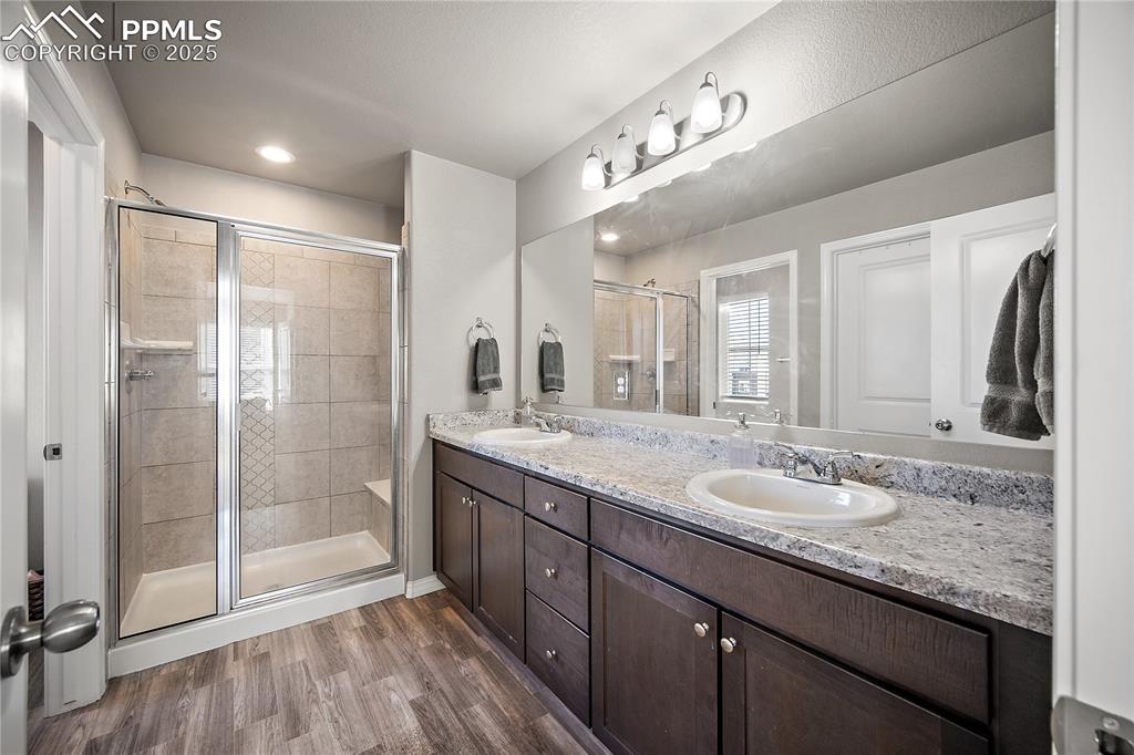 Image 21 of 36: Primary bath with free standing shower and double vanity.