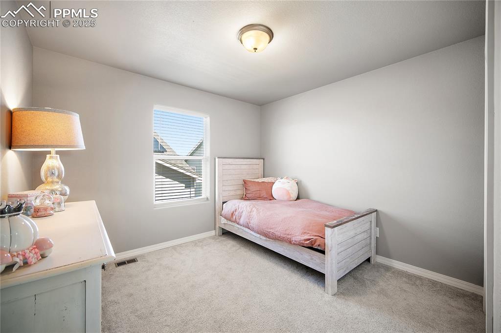 Image 24 of 36: Upstairs bedroom 2 with carpet and spacious closet.