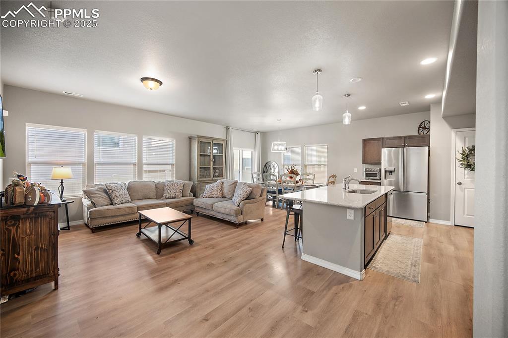 Image 5 of 36: Open concept main level. Tall ceilings, laminate flooring, natural light.