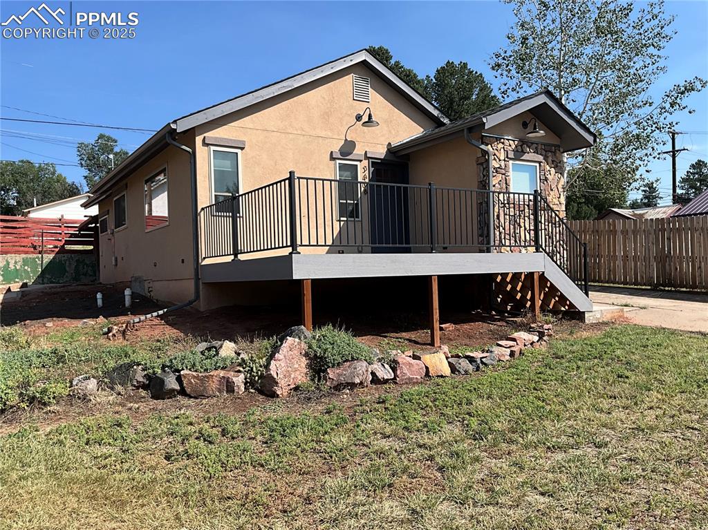 Image 2 of 50: Front of property featuring a composite deck, stucco siding, and stone sidi
