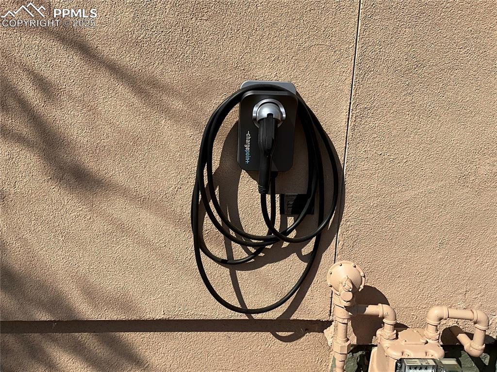 Image 47 of 50: Detailed view of electric vehicle charger and stucco siding.