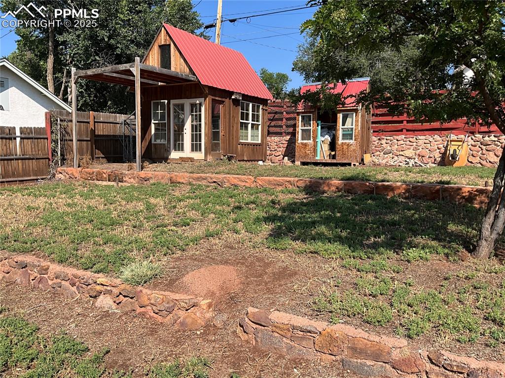 Image 5 of 50: View of yard, a Artists studio and shed.