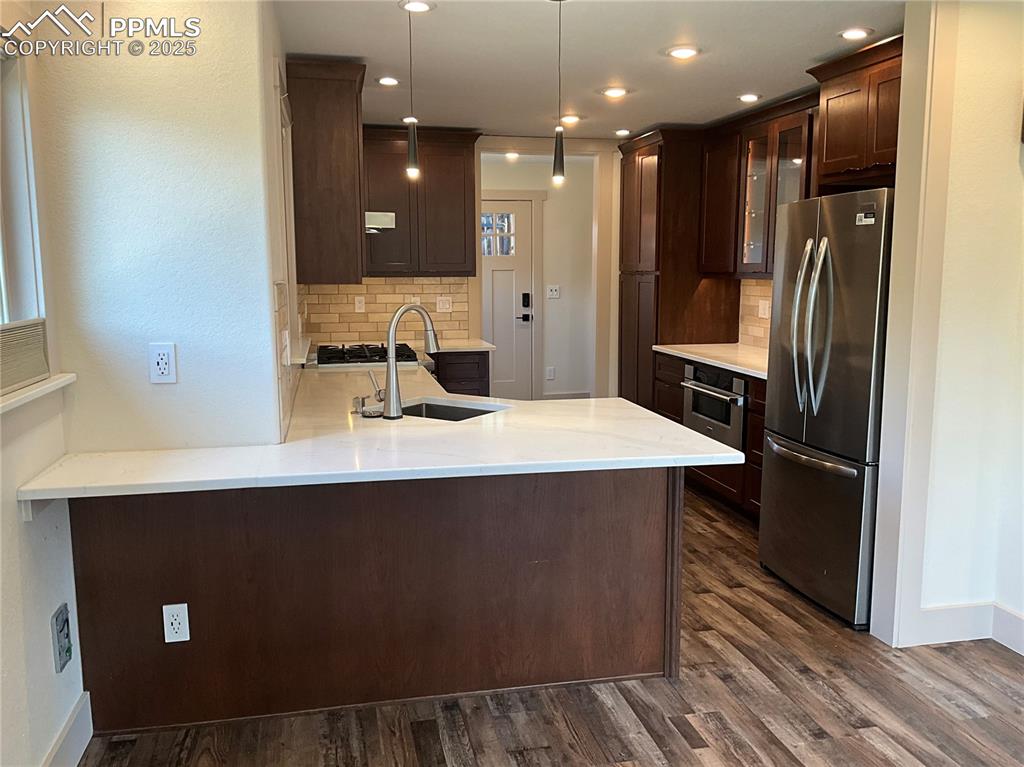 Image 6 of 50: Kitchen with Cherry Charcoal cabinetry, stainless steel appliances, backspl