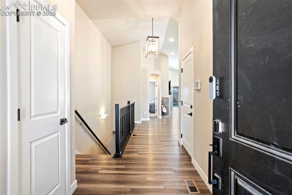 Image 12 of 41: Foyer entrance with dark wood-style floors and high vaulted ceiling