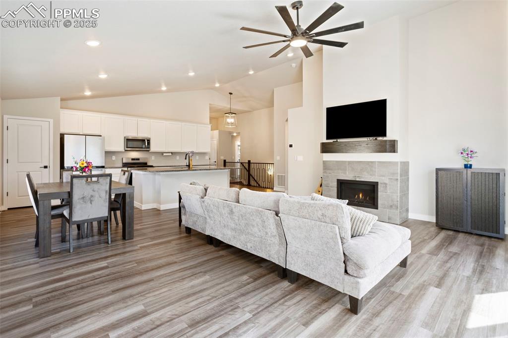 Image 15 of 41: Living area with high vaulted ceiling, light wood finished floors, a tiled