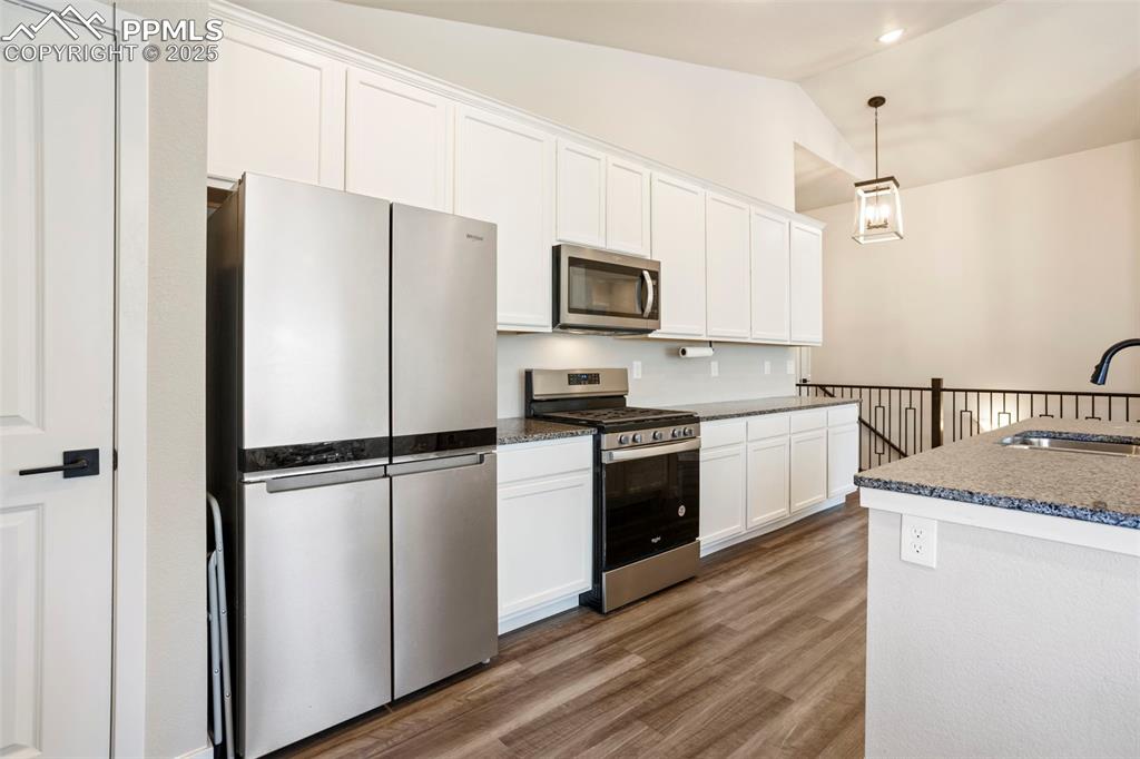 Image 17 of 41: Kitchen featuring appliances with stainless steel finishes, white cabinetry
