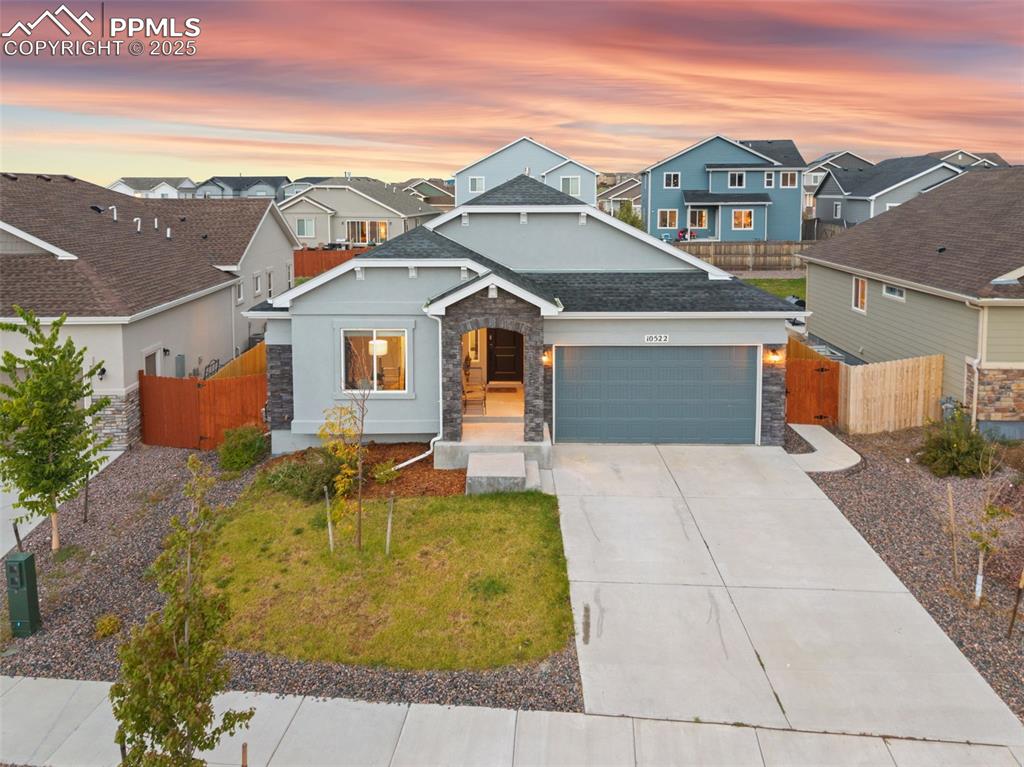 Image 2 of 41: View of front of home with stone siding, a residential view, driveway, and