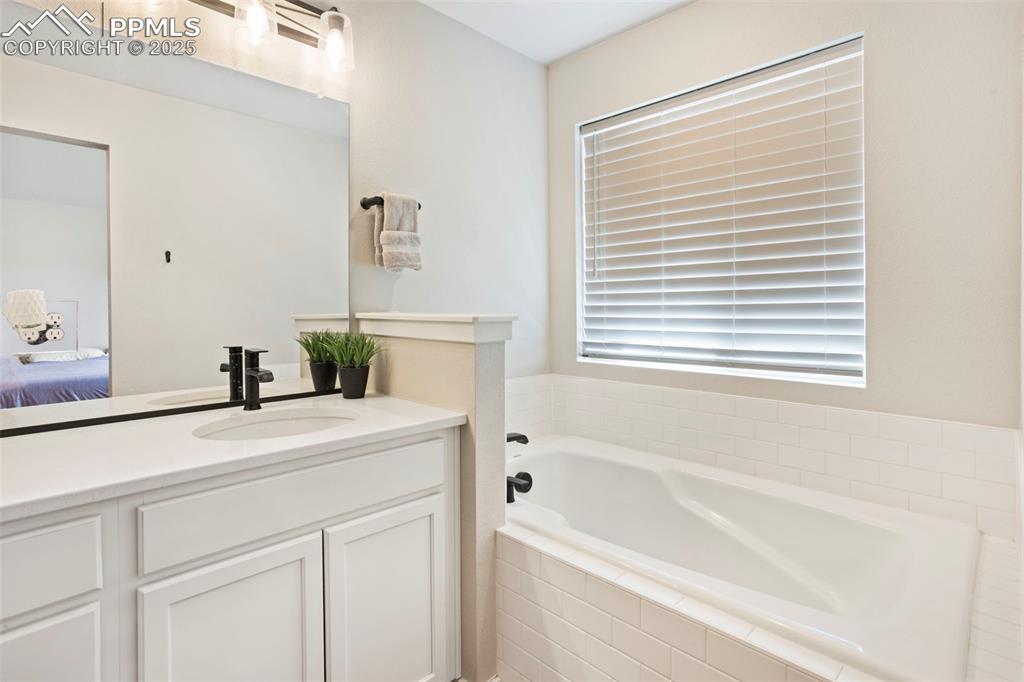 Image 25 of 41: Full bath with vanity, a bath, and ensuite bath