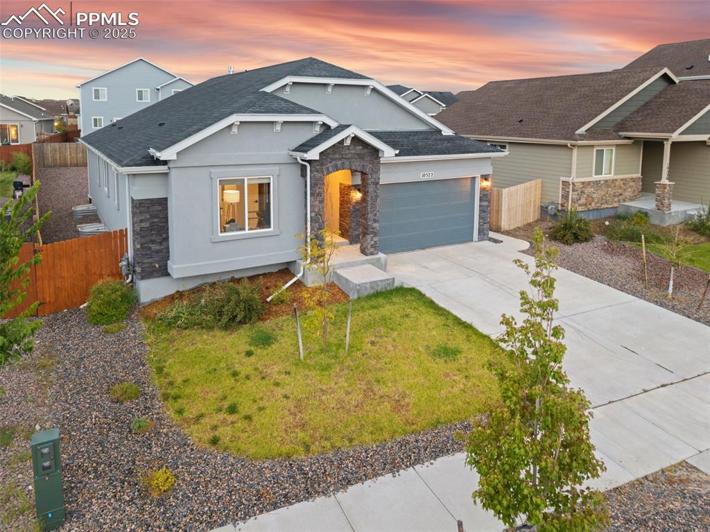 Image 3 of 41: Craftsman house featuring stucco siding, stone siding, concrete driveway, a