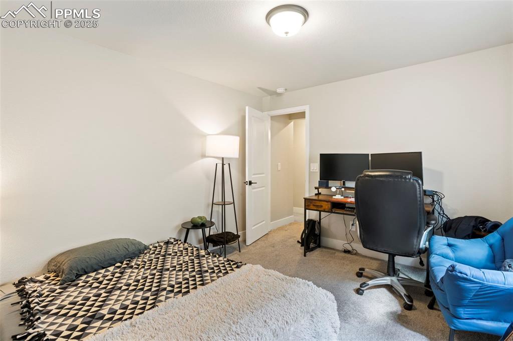 Image 36 of 41: Bedroom featuring an office area and light colored carpet