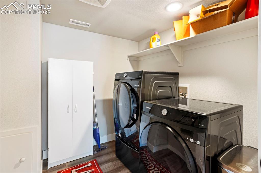 Image 41 of 41: Laundry area featuring washer and clothes dryer and dark wood finished floo