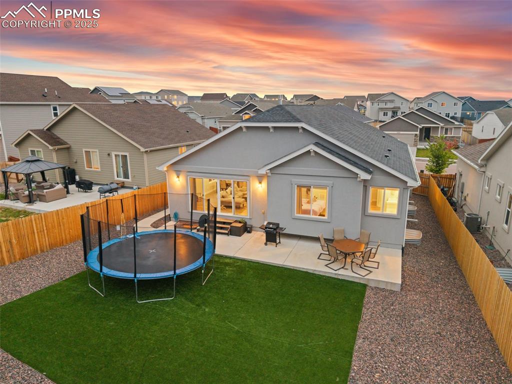 Image 8 of 41: Back of house at dusk with a patio area, stucco siding, an outdoor living s