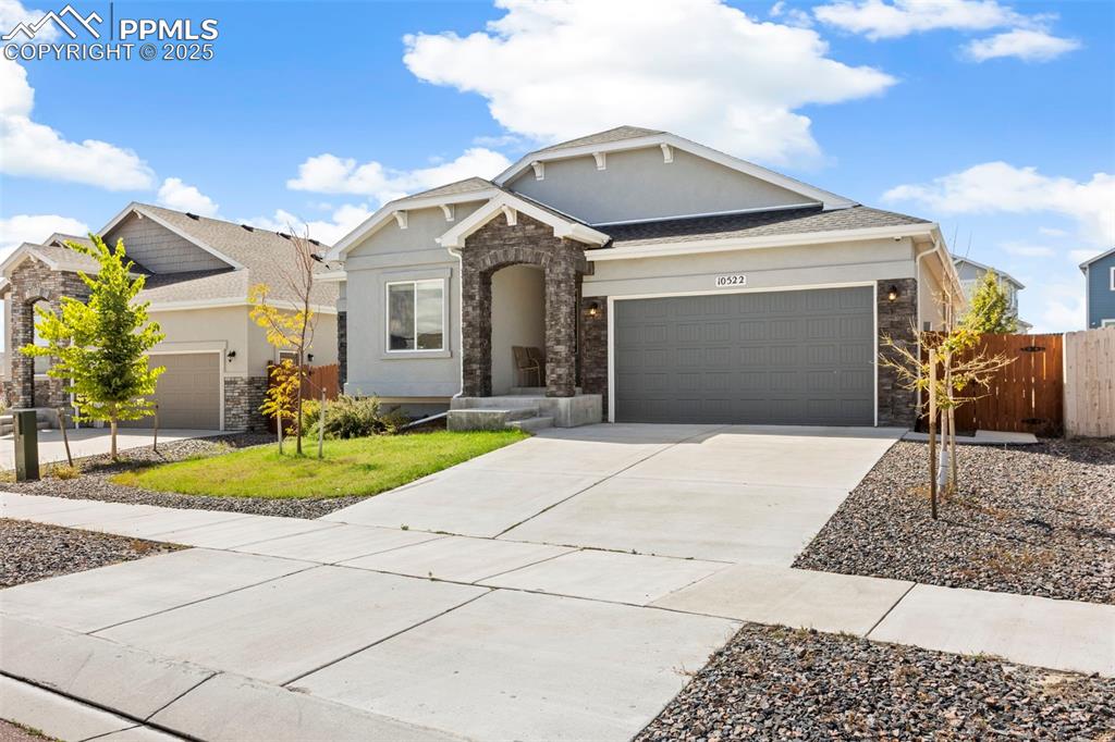 Image 9 of 41: Craftsman house featuring stone siding, concrete driveway, an attached gara