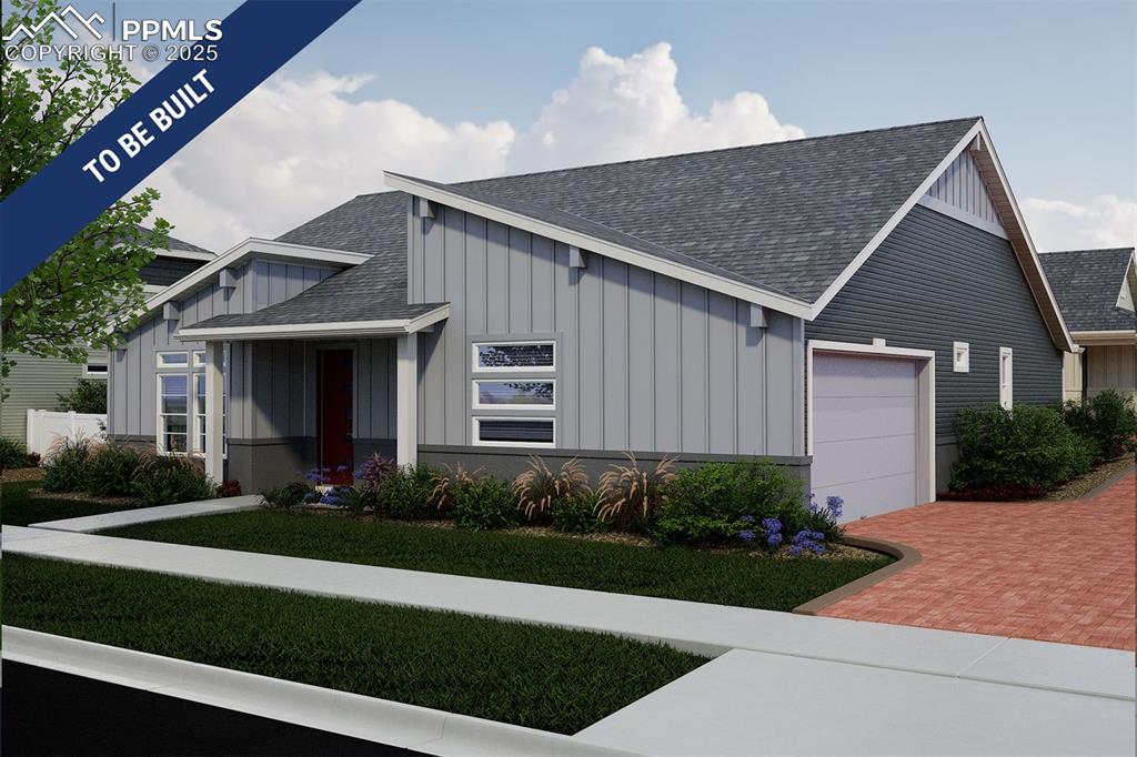 Caption: View of front facade featuring board and batten siding, a shingled roof, decorative driveway, and a 