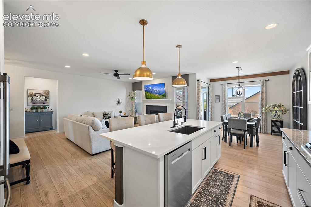 Image 10 of 46: Expansive kitchen island with a built-in sink and dishwasher, featuring whi