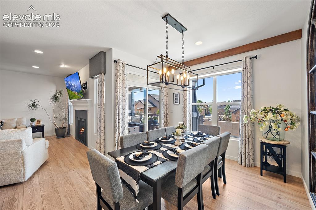 Image 12 of 46: Open-concept dining area featuring wood-finish flooring, a contemporary cha