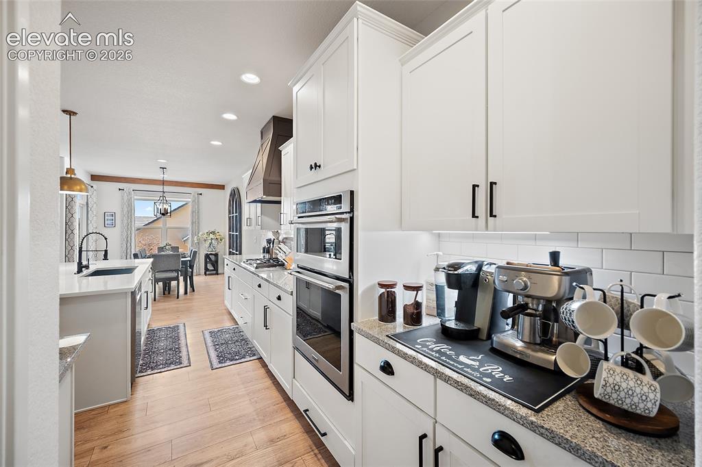 Image 13 of 46: Modern kitchen featuring white shaker cabinetry, stainless steel appliances