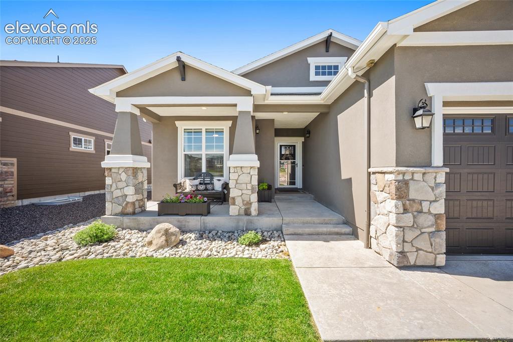 Image 2 of 46: Stucco exterior with stone accents and a covered front porch