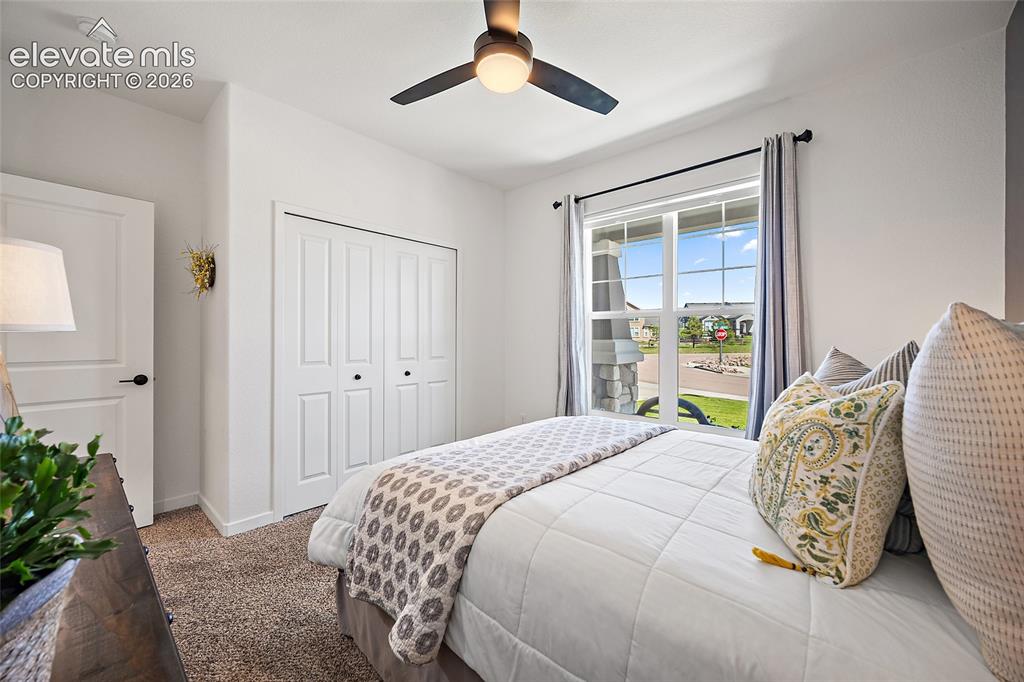 Image 21 of 46: Bedroom featuring a multi-pane window, bi-fold closet doors, a ceiling fan 