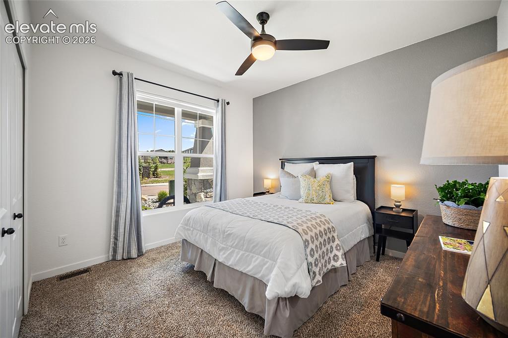 Image 22 of 46: Carpeted room featuring a large window, a black ceiling fan with an integra