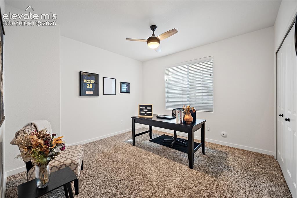 Image 23 of 46: Room featuring a ceiling fan with integrated lighting, a window with horizo
