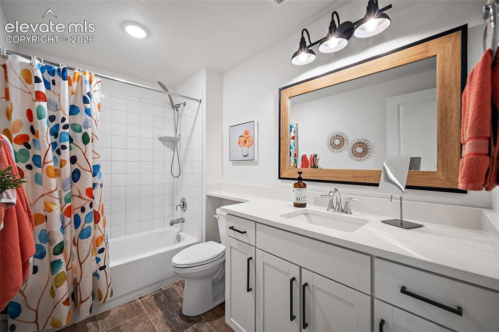 Image 24 of 46: Bathroom featuring a white subway tile tub surround, white vanity with inte