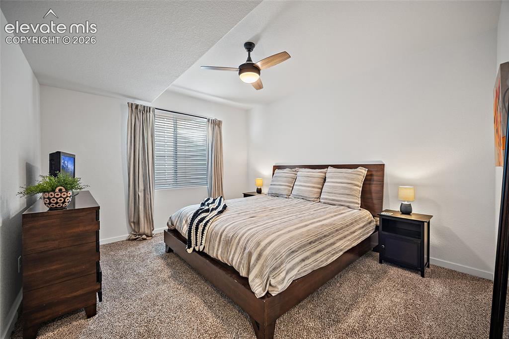 Image 27 of 46: Carpeted bedroom featuring a ceiling fan with integrated lighting, a window
