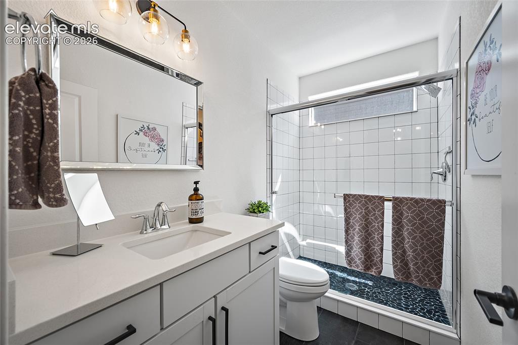Image 31 of 46: Bathroom featuring a single vanity with a white countertop and undermount s