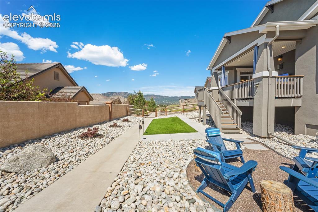 Image 32 of 46: Outdoor living area featuring a ground-level patio with a gravel fire pit, 