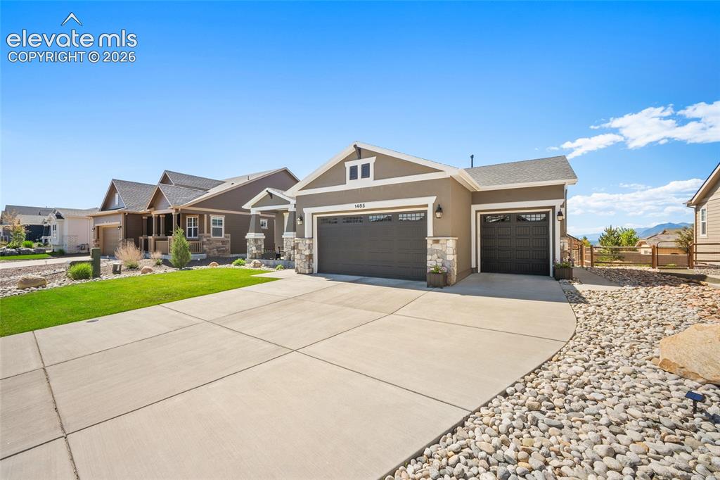 Image 40 of 46: Contemporary ranch-style exterior featuring a neutral stucco and stone faca
