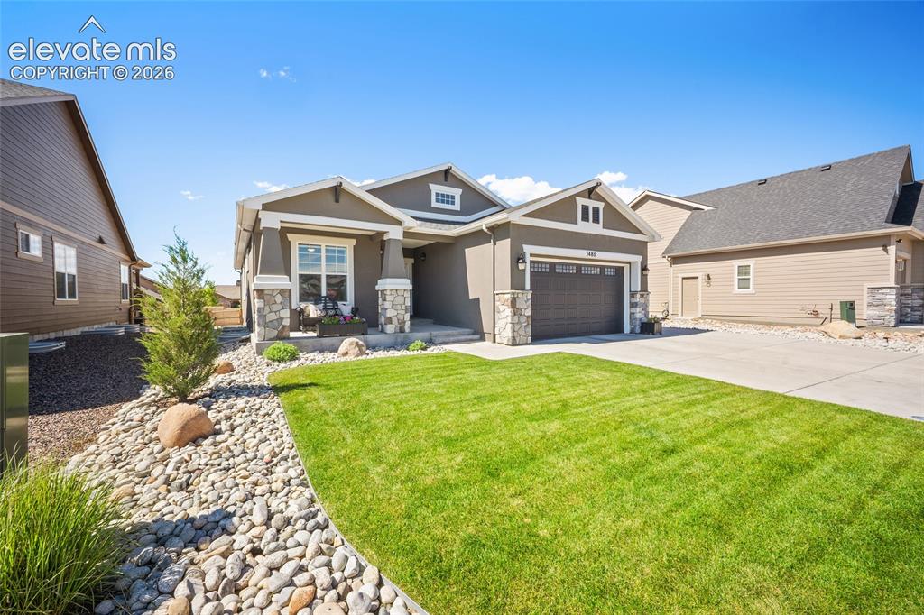 Image 43 of 46: Contemporary stucco exterior with stone accents, a covered front porch, and
