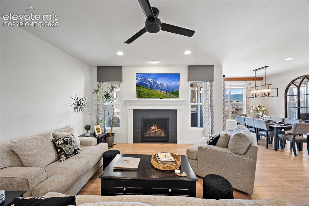 Image 5 of 46: Open-concept living space featuring wood-finish flooring, a contemporary fi