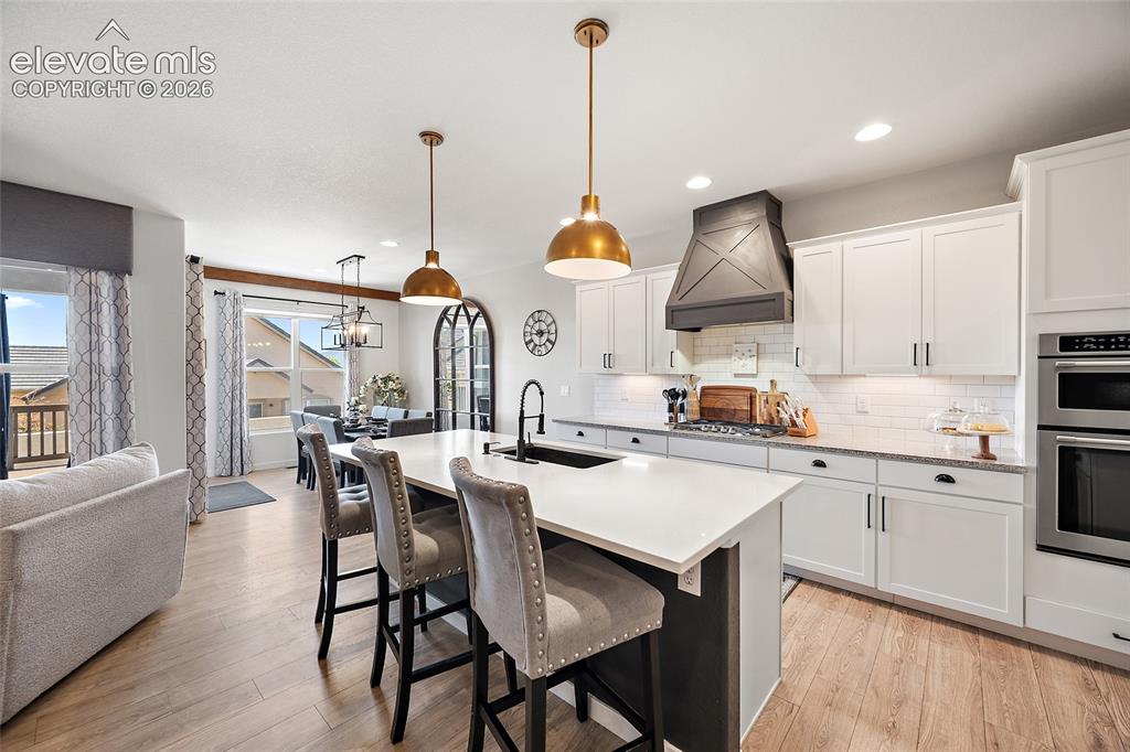 Image 8 of 46: Open-concept kitchen featuring an oversized island with seating, white shak
