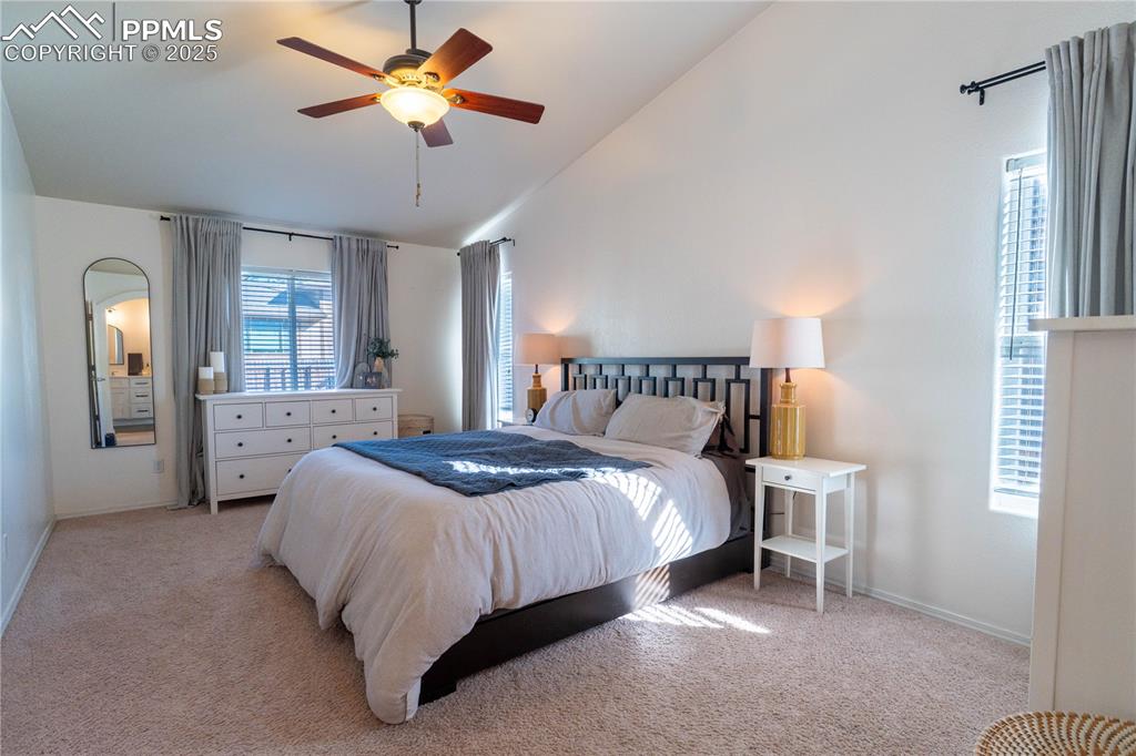 Image 10 of 26: Bedroom with carpet, ceiling fan, and high vaulted ceiling