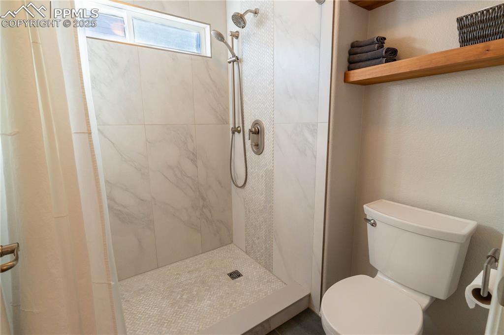 Image 13 of 26: Bathroom with a stall shower and toilet
